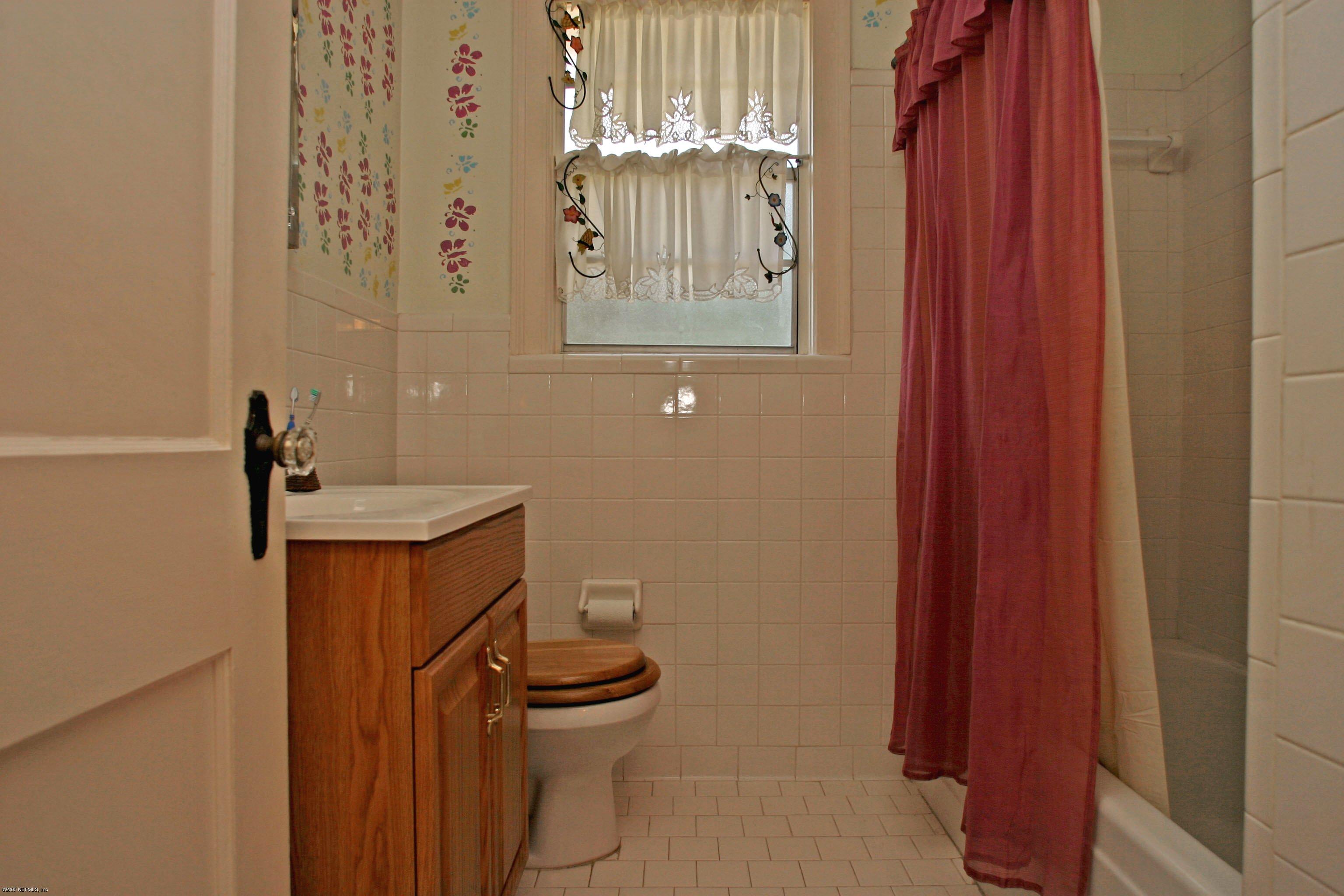 1510 Nicholson Road Jacksonville, FL 32207 - Photo 10 of 14 a bathroom with a sink a toilet and shower curtain