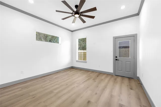 a view of a big room with wooden floor and a chandelier fan