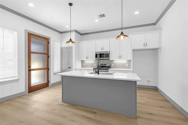 a kitchen with kitchen island a sink and a refrigerator