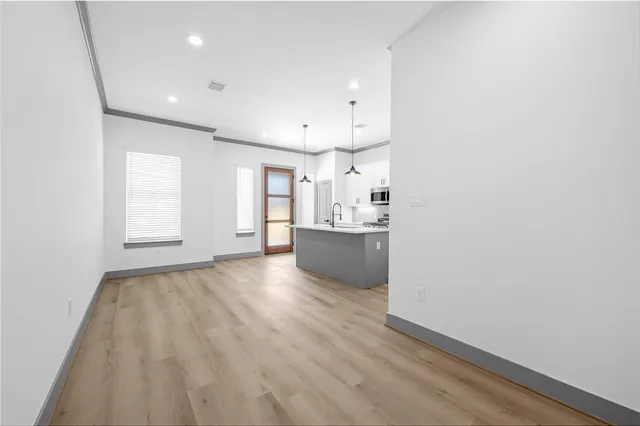 a view of kitchen and hall with wooden floor