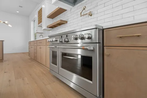 a large kitchen with stainless steel appliances granite countertop a granite counter tops and a wooden floors