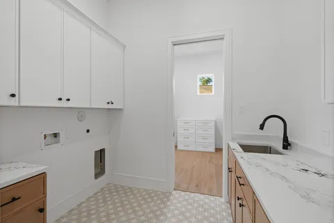 a view of an empty room with wooden floor and windows