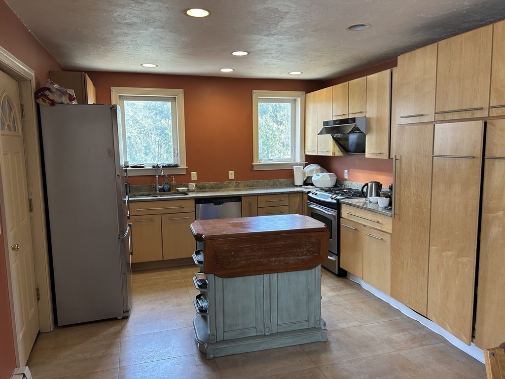 7 Wingate Street Shrewsbury, MA 01545 - Photo 4 of 21 a kitchen with kitchen island a counter top space appliances a sink and a refrigerator