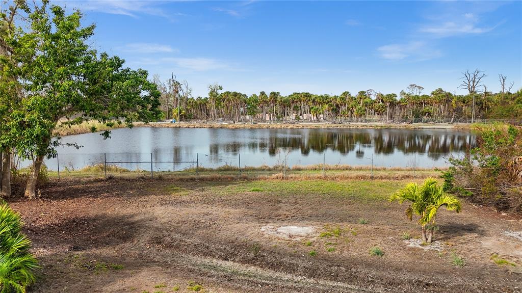 4260 Placida Road, Unit 14C Englewood, FL 34224 - Photo 13 of 37 a view of a lake with a yard and large trees