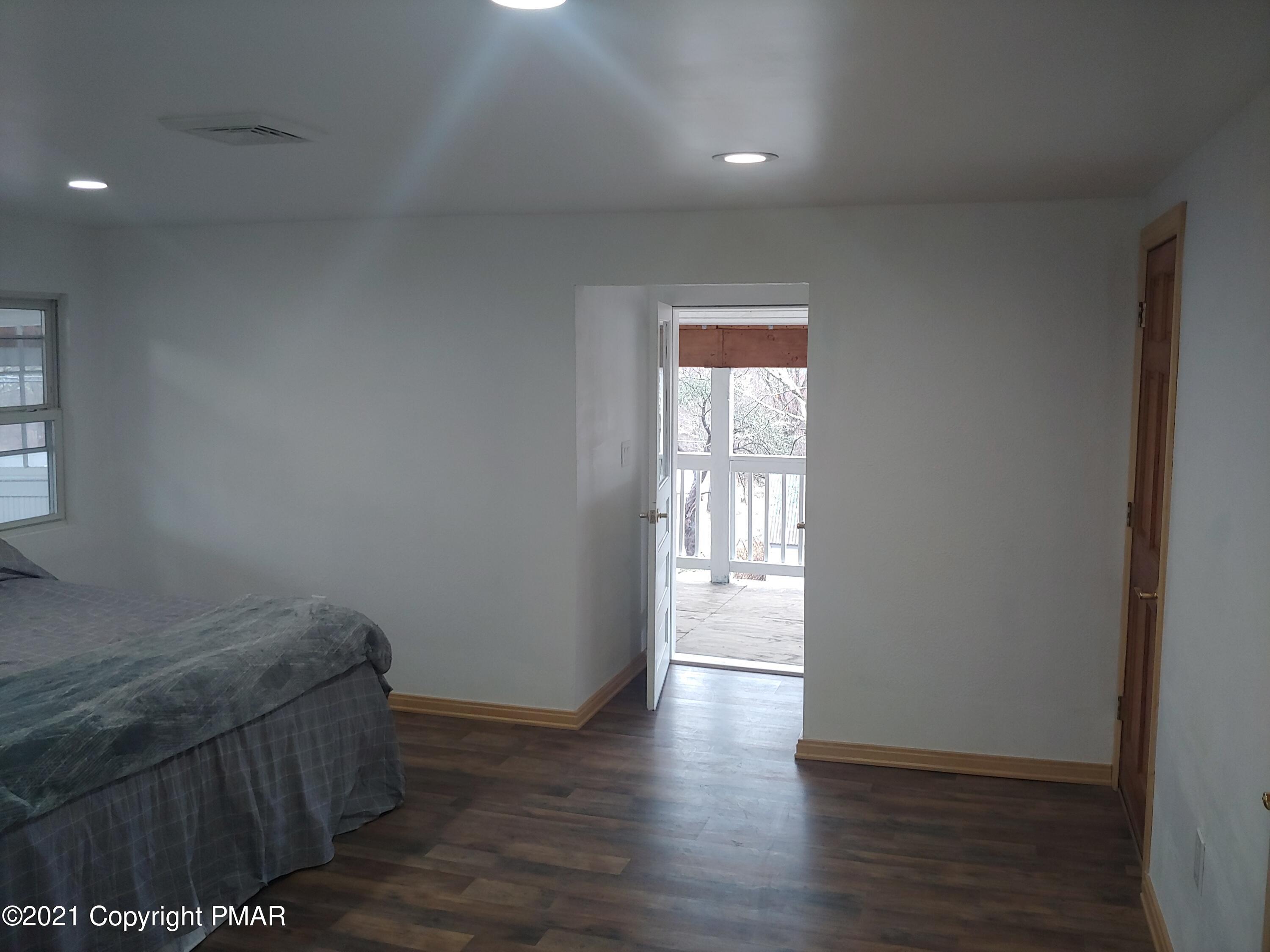 516 Red Rock Road Cresco, PA 18326 - Photo 23 of 47 an empty room with wooden floor and windows