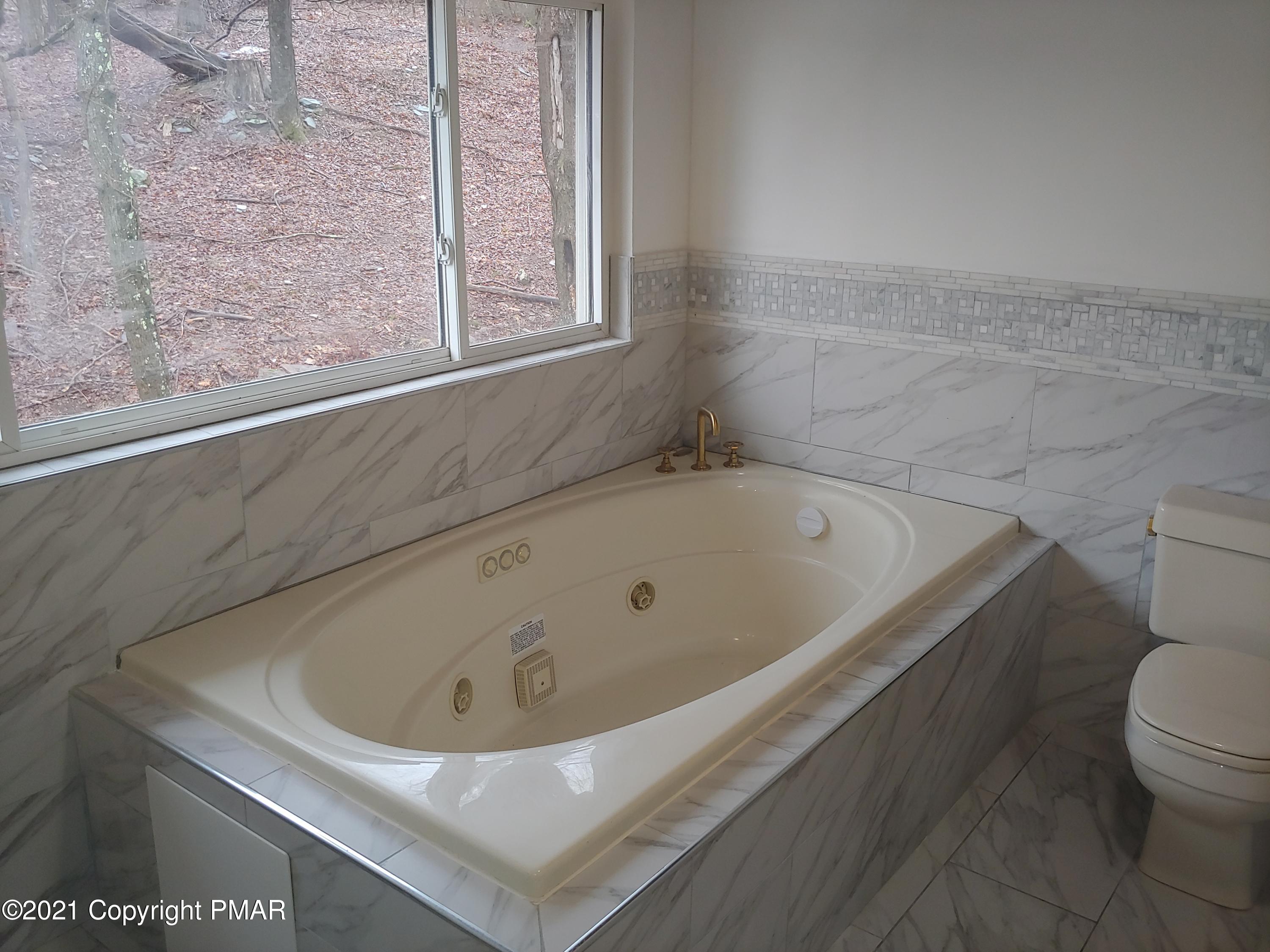 516 Red Rock Road Cresco, PA 18326 - Photo 27 of 47 a bathroom with a white bath tub and a toilet