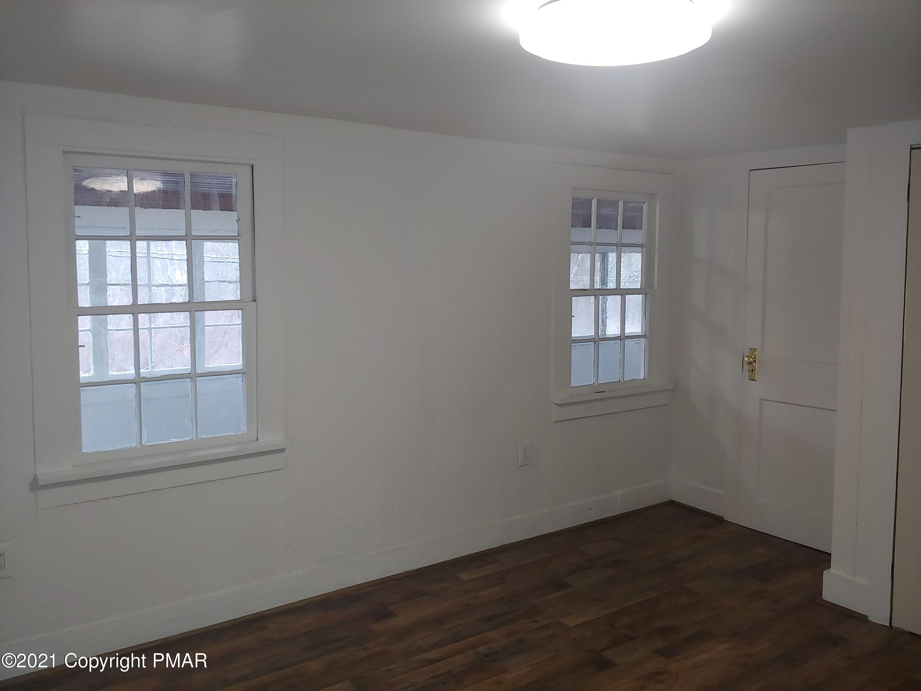 516 Red Rock Road Cresco, PA 18326 - Photo 32 of 47 an empty room with wooden floor and windows