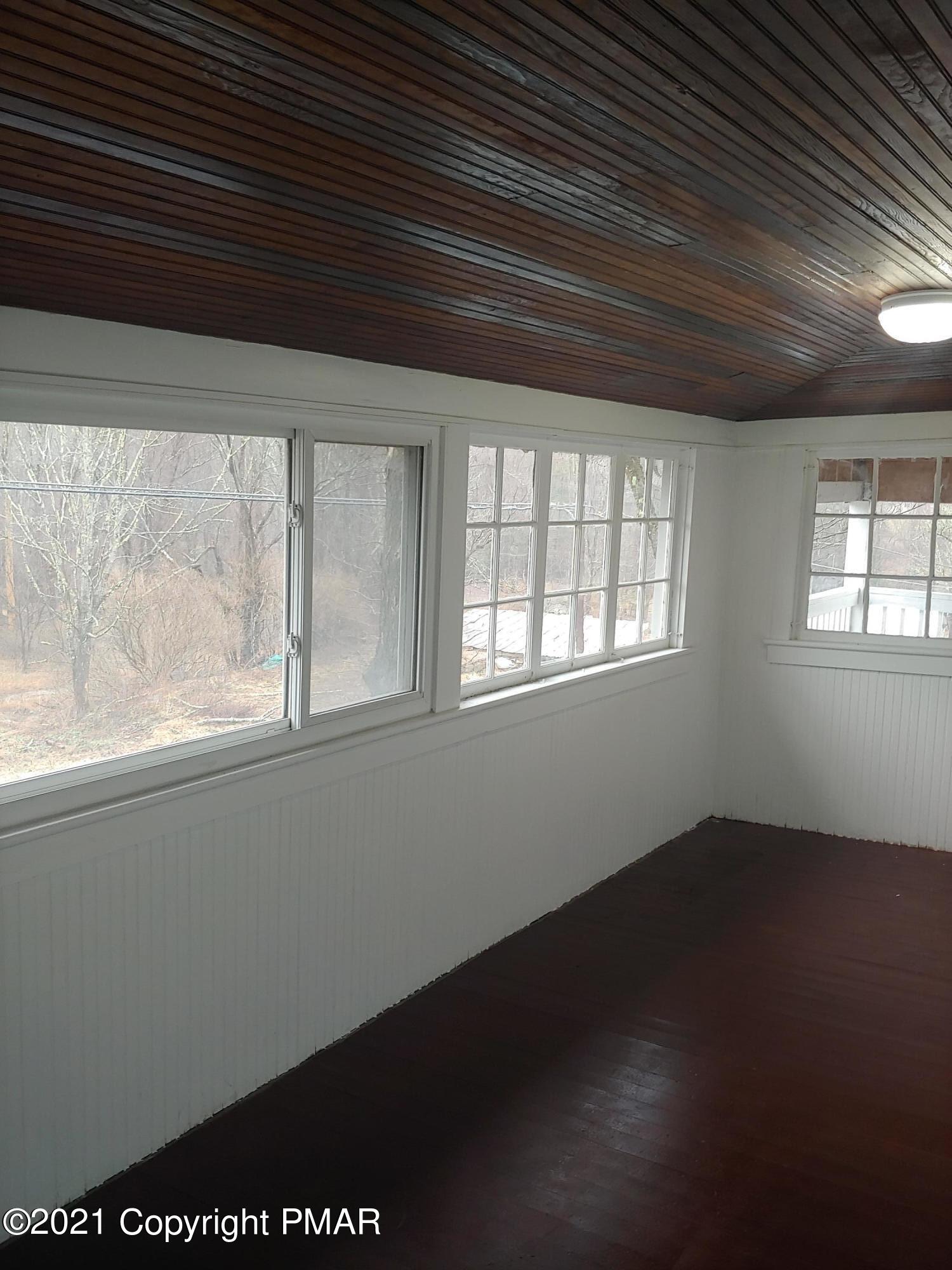 516 Red Rock Road Cresco, PA 18326 - Photo 39 of 47 an empty room with wooden floor and windows