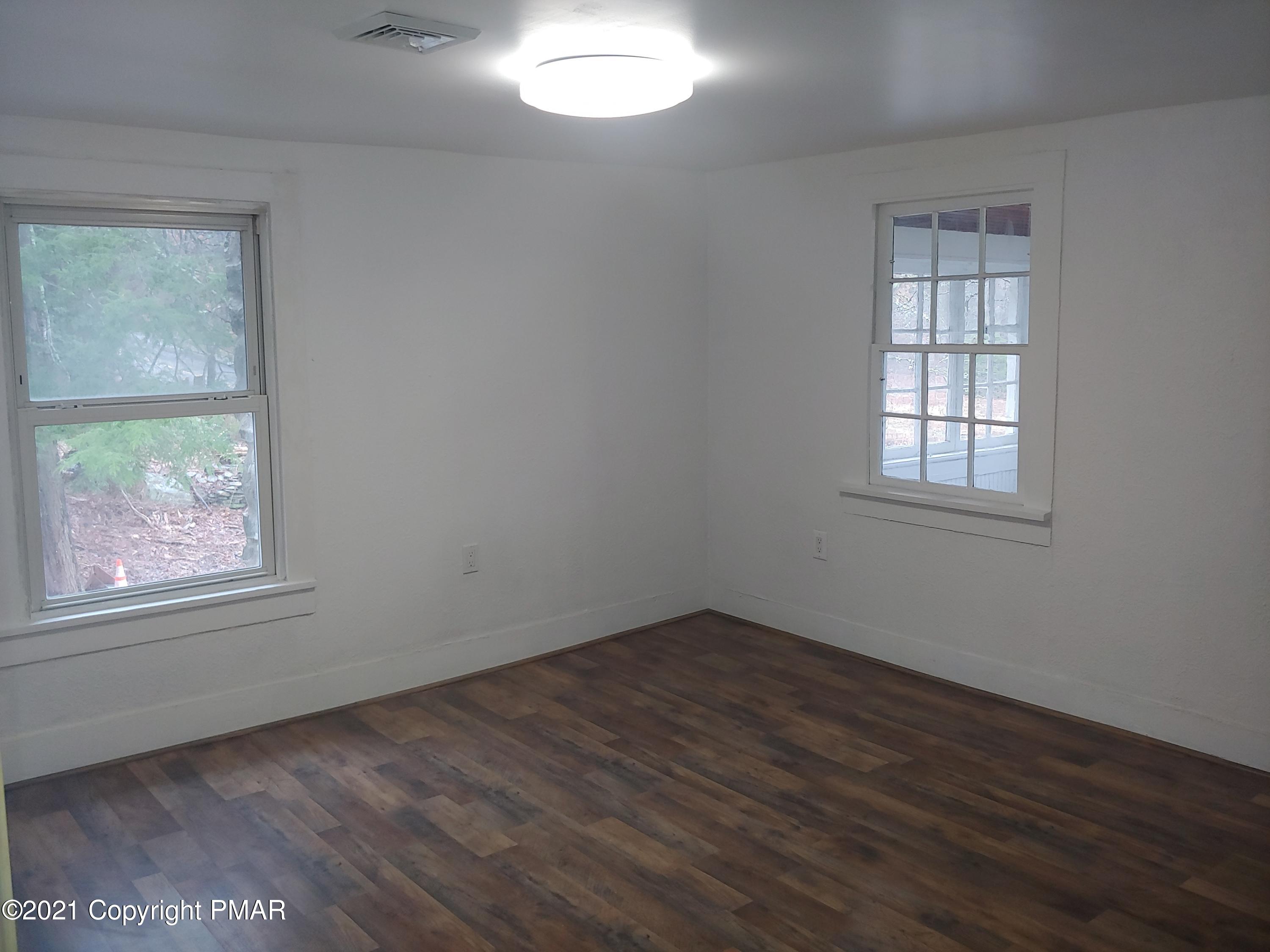 516 Red Rock Road Cresco, PA 18326 - Photo 40 of 47 an empty room with wooden floor and windows