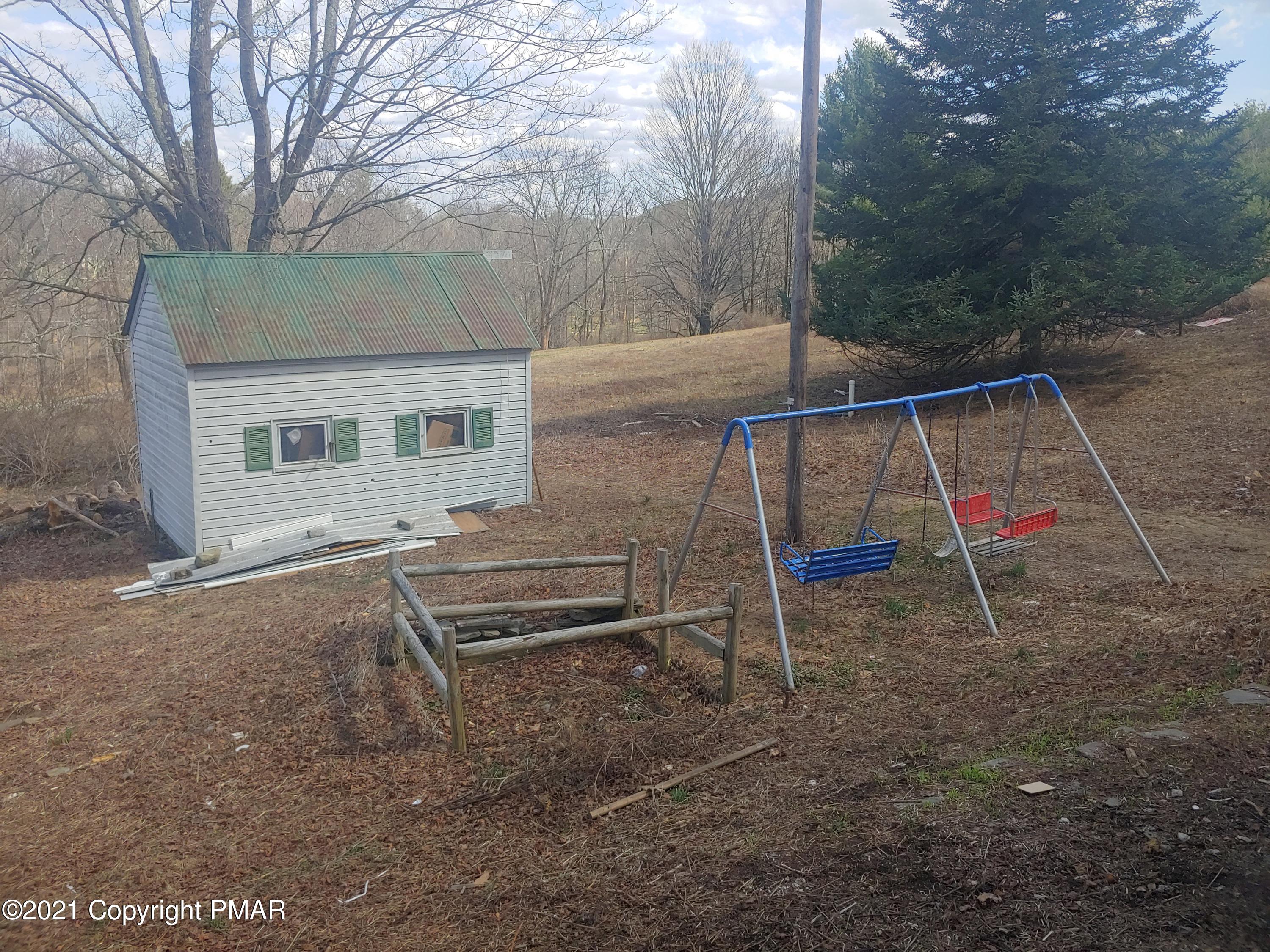 516 Red Rock Road Cresco, PA 18326 - Photo 44 of 47 a backyard of a house with wooden stairs and bench