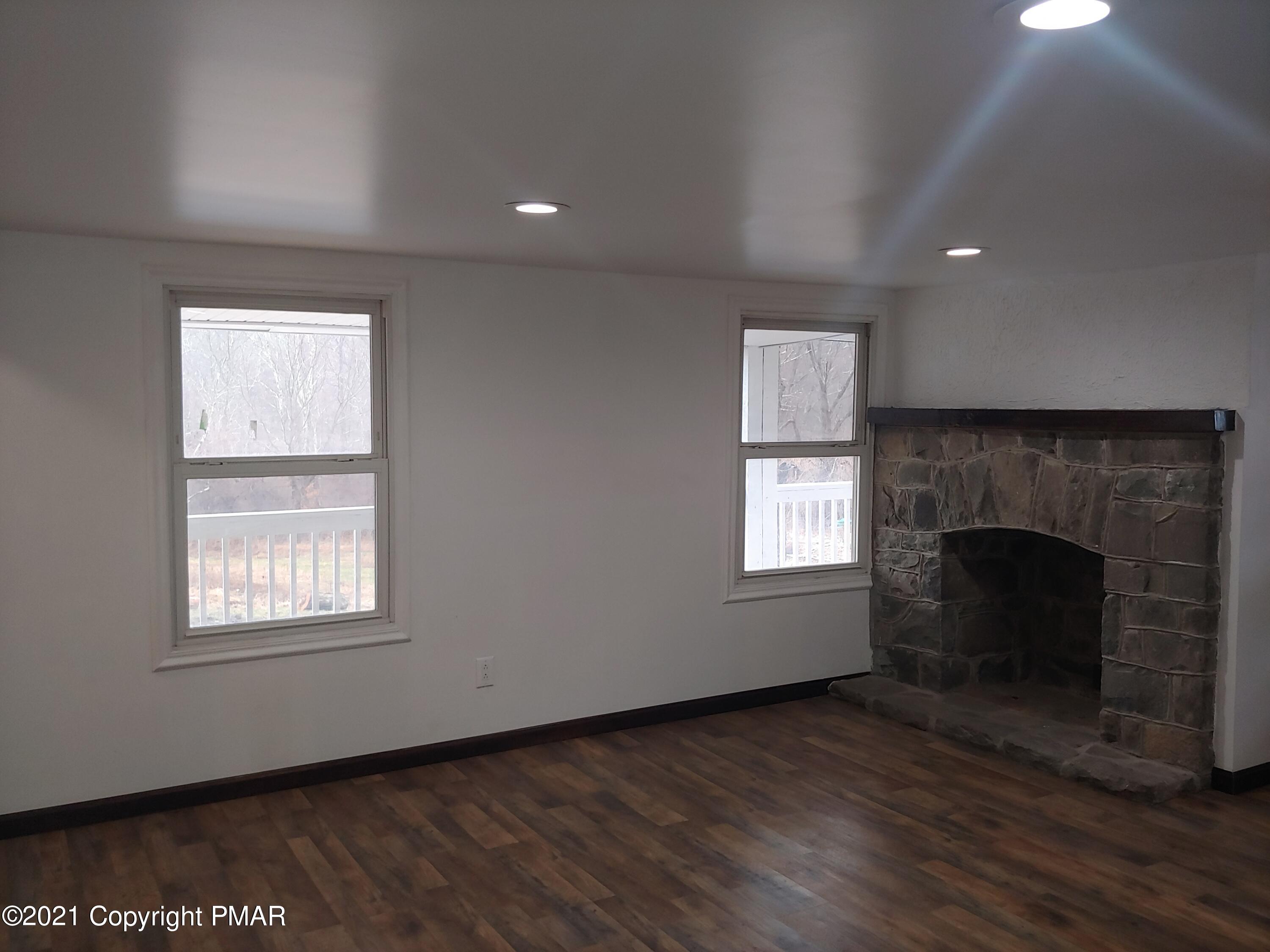 516 Red Rock Road Cresco, PA 18326 - Photo 6 of 47 an empty room with windows and fireplace