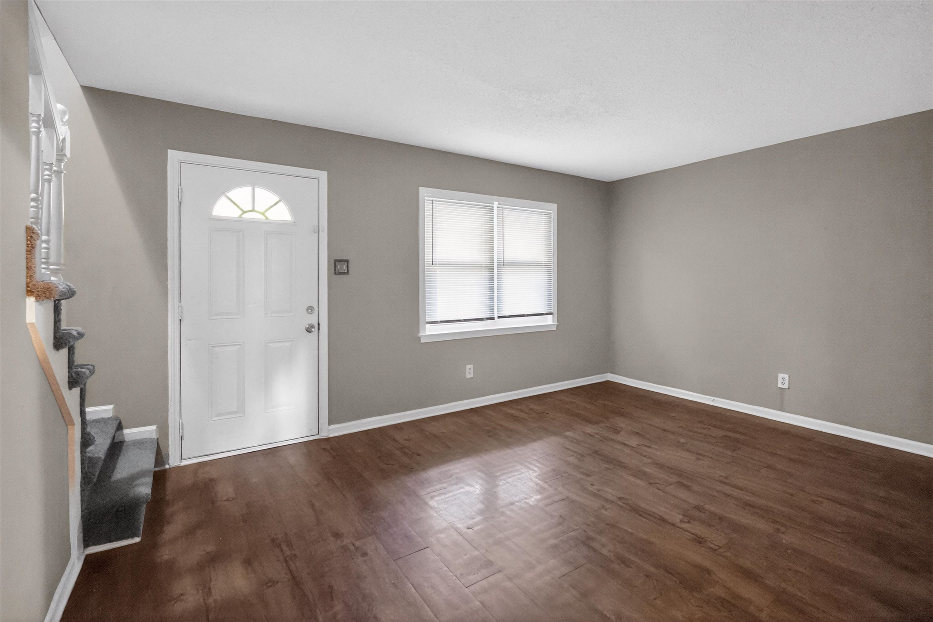 5124 Gill Road Memphis, TN 38109 - Photo 11 of 33 Spacious living area featuring wood-finish flooring, neutral wall tones, and a bright window with blinds