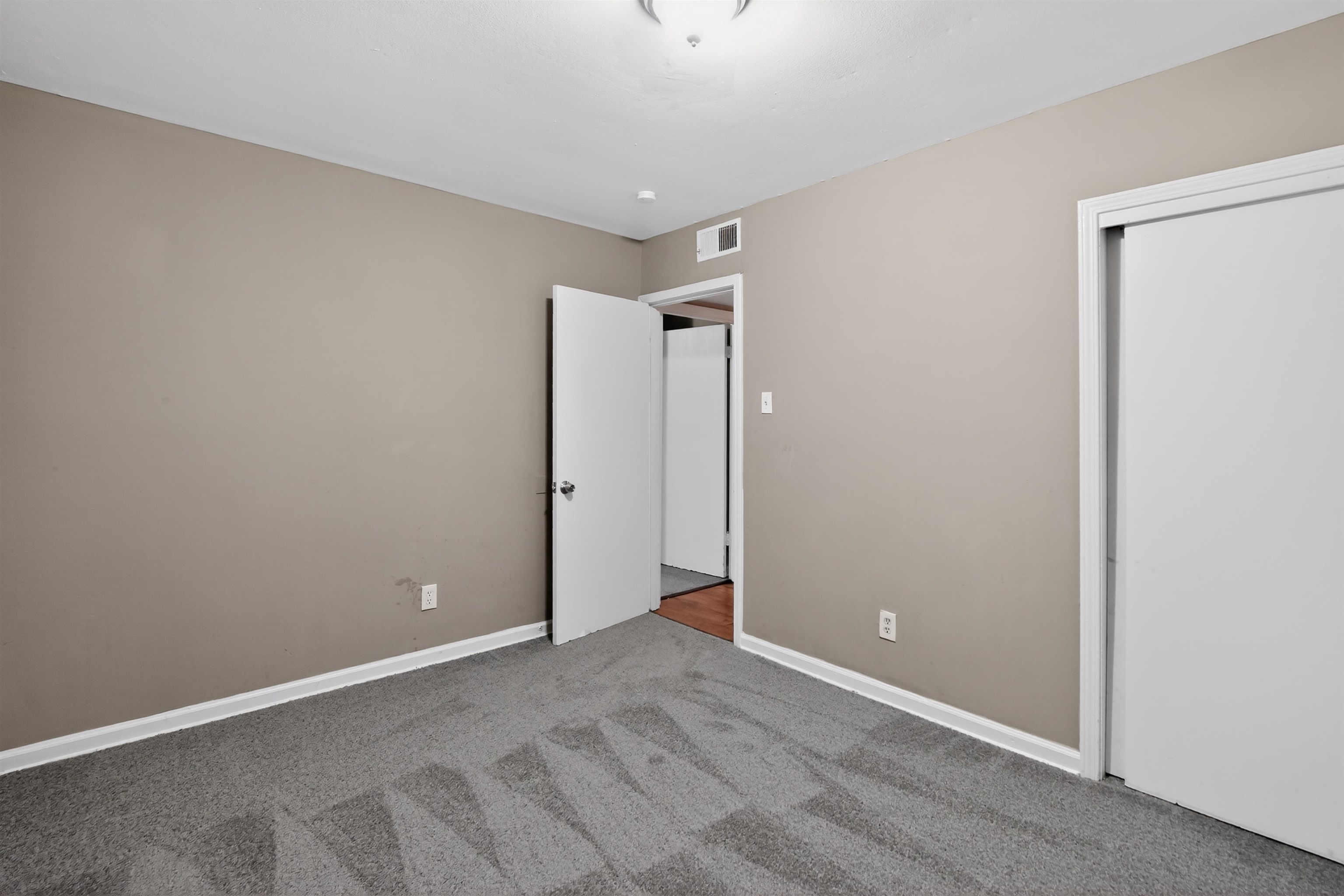 5124 Gill Road Memphis, TN 38109 - Photo 21 of 33 Carpeted room featuring neutral-toned walls, white trim, a ceiling light fixture, a white interior door, and a white sliding closet door