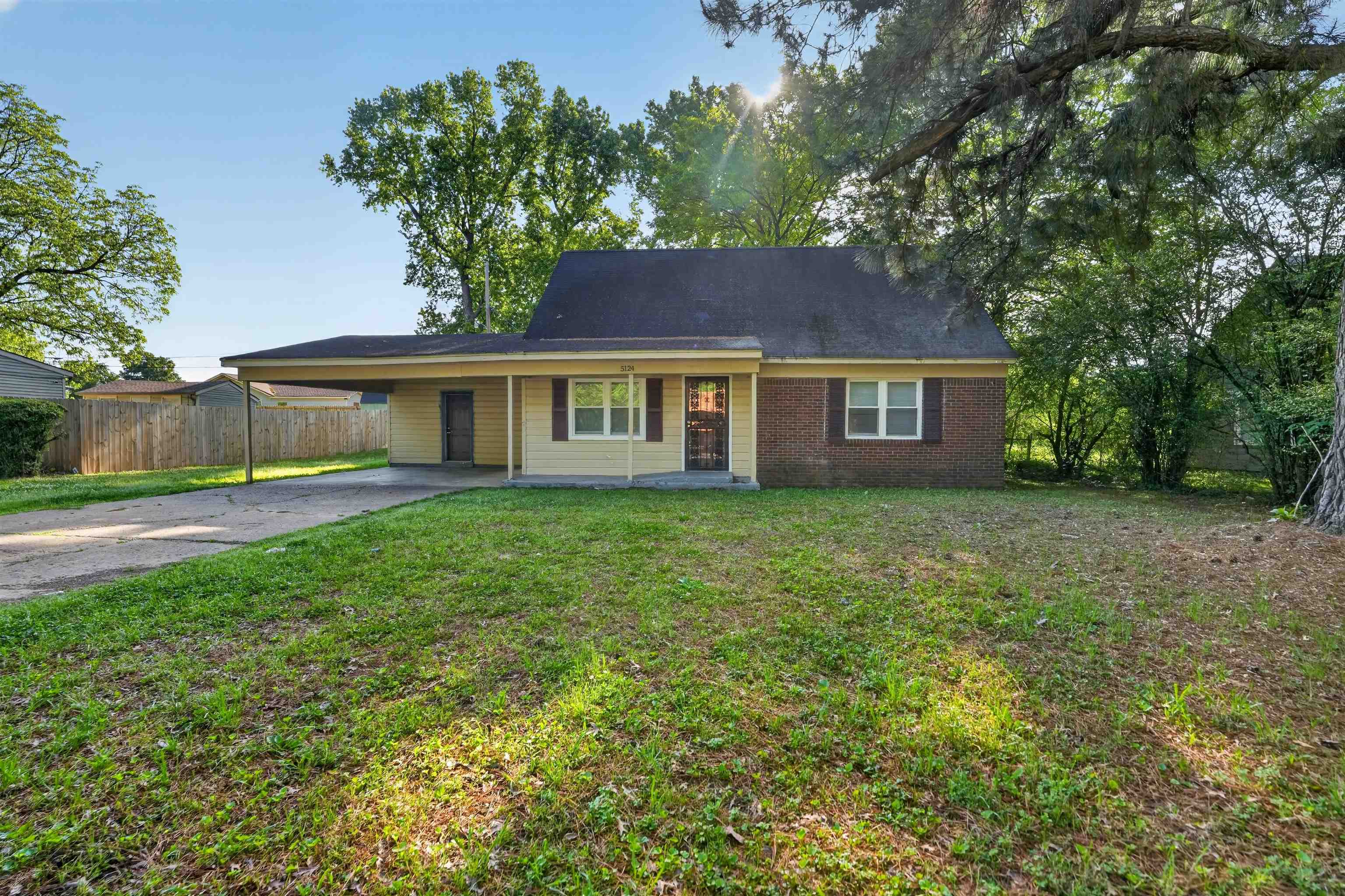 5124 Gill Road Memphis, TN 38109 - Photo 3 of 33 Ranch-style residence featuring a brick facade, carport, and mature trees framing the property