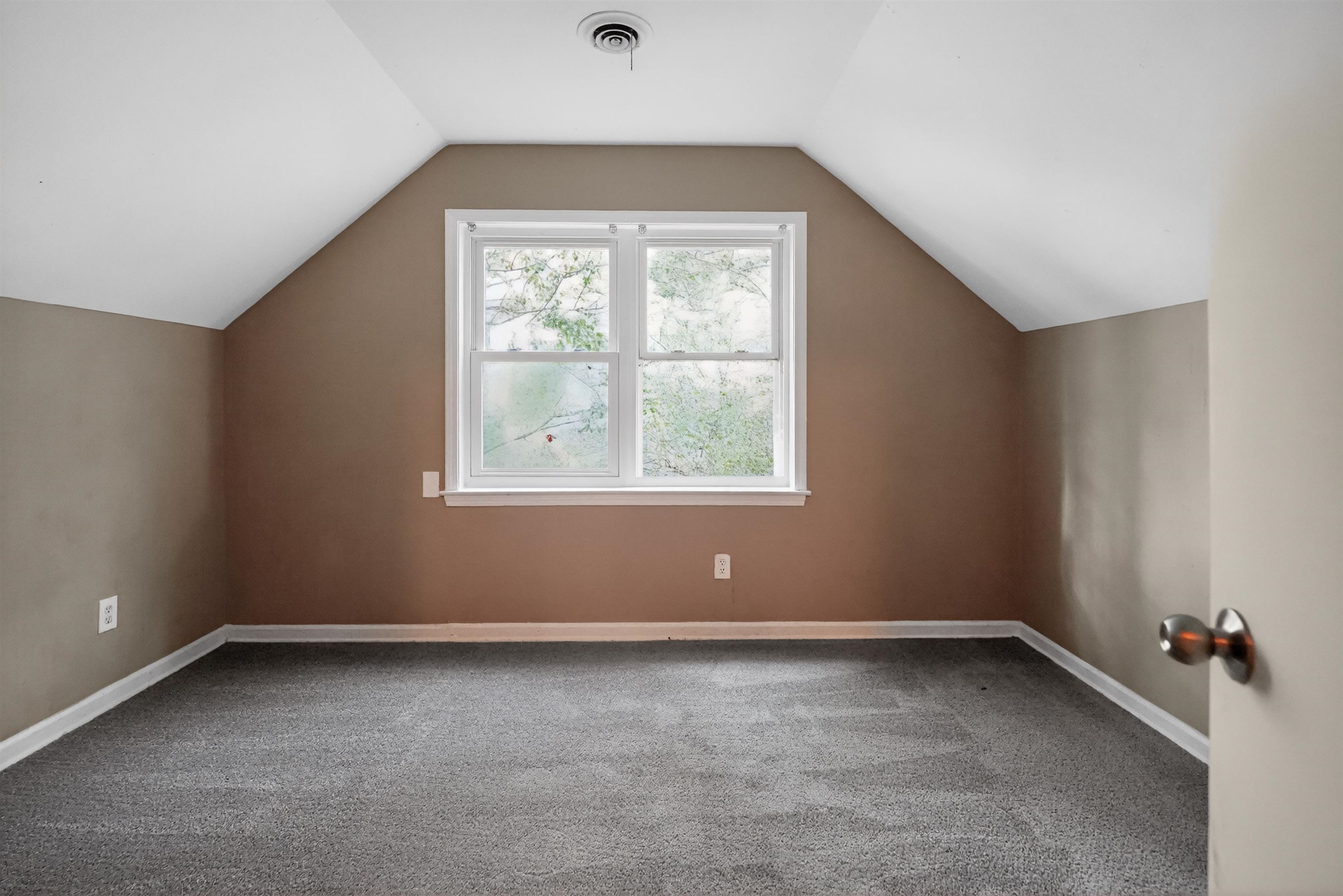 5124 Gill Road Memphis, TN 38109 - Photo 33 of 33 Spacious room featuring sloped ceilings, a double window, neutral wall paint, and gray carpet flooring