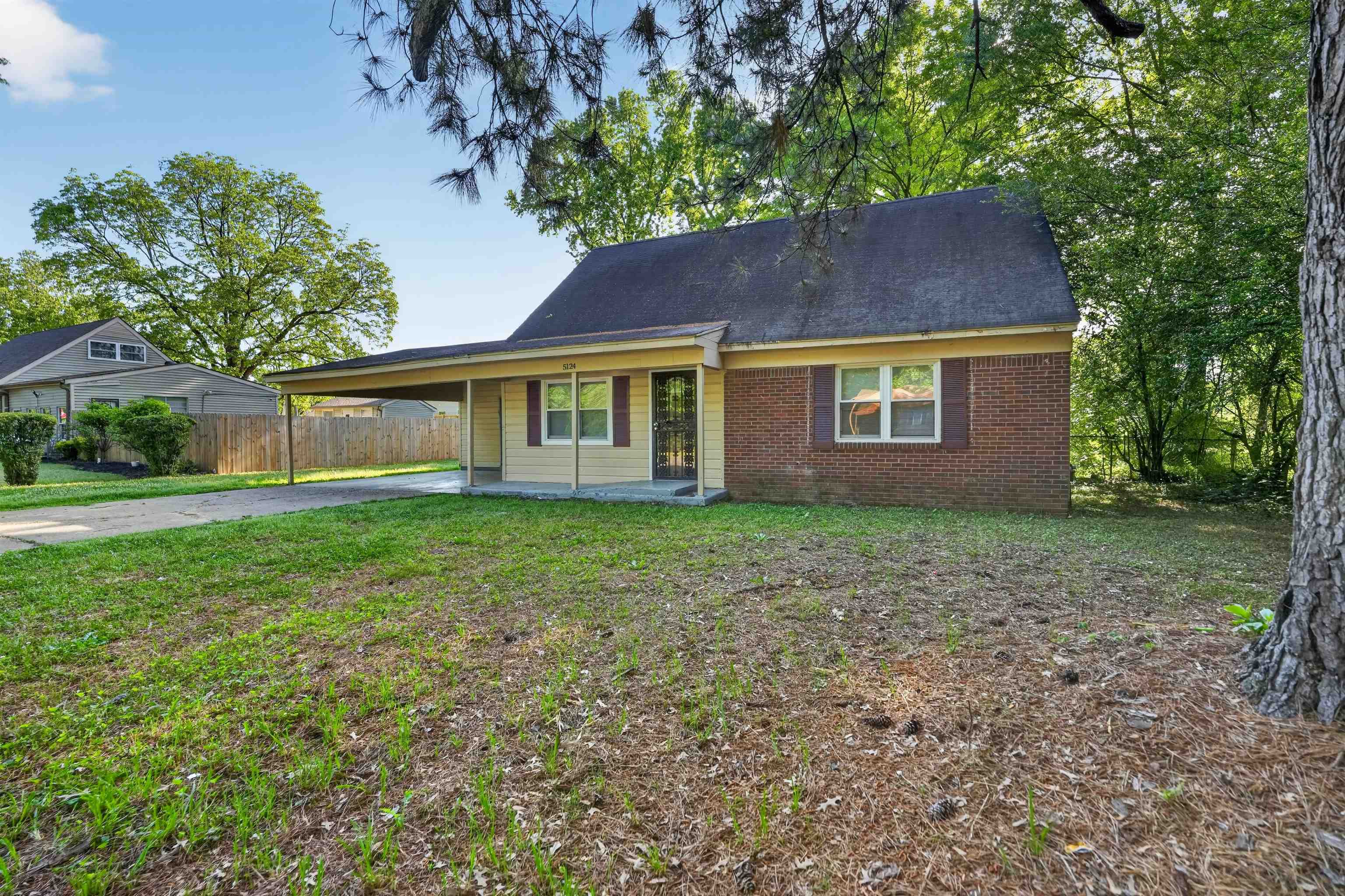 5124 Gill Road Memphis, TN 38109 - Photo 5 of 33 Exterior featuring a combination of brick and siding, a covered carport, and a dark shingle roof