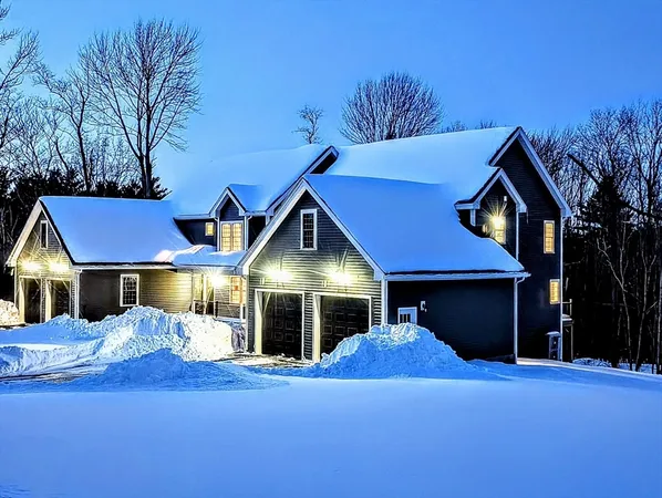 a front view of a house with yard and parking