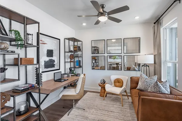 a living room with furniture a large window and wooden floor