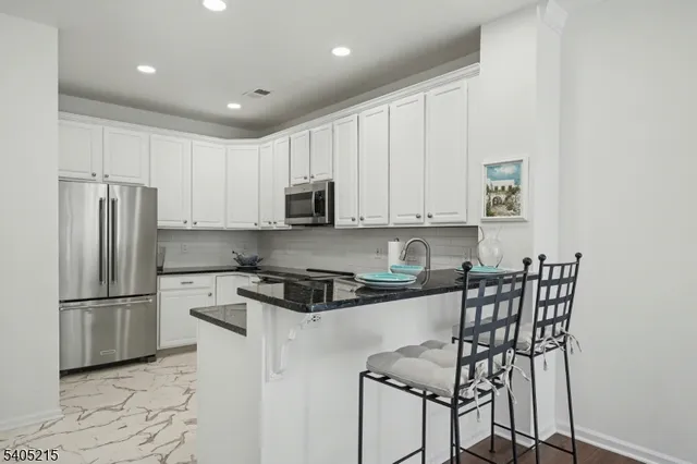 a kitchen with stainless steel appliances granite countertop a refrigerator and a stove top oven