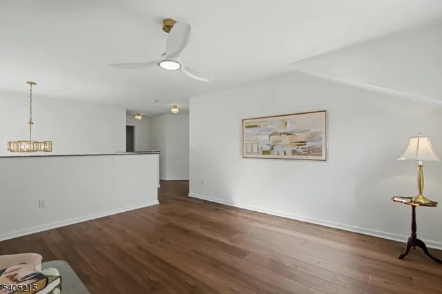 a view of a room with wooden floor and ceiling fan