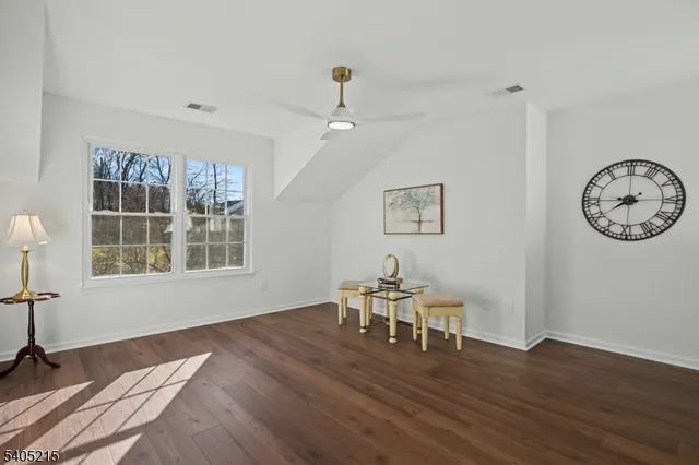a view of a room with wooden floor a chandelier a wooden table and chairs