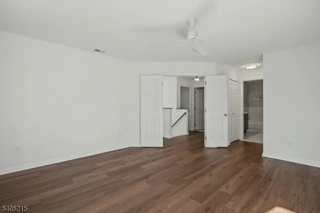 a view of a big room with wooden floor and windows