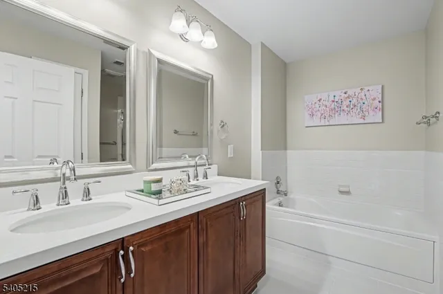 a bathroom with a tub a sink and mirror