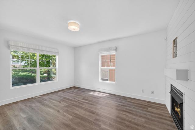14771 Haddington Road Draper, UT 84020 - Photo 4 of 44 Spacious room featuring wood-finish flooring, white baseboards, and a fireplace with a white shiplap surround