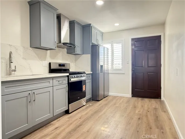 a kitchen with a refrigerator stove top oven and sink