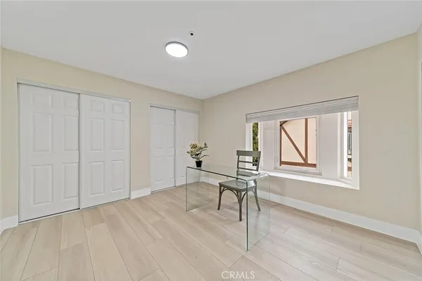 a workspace room with wooden floor and windows