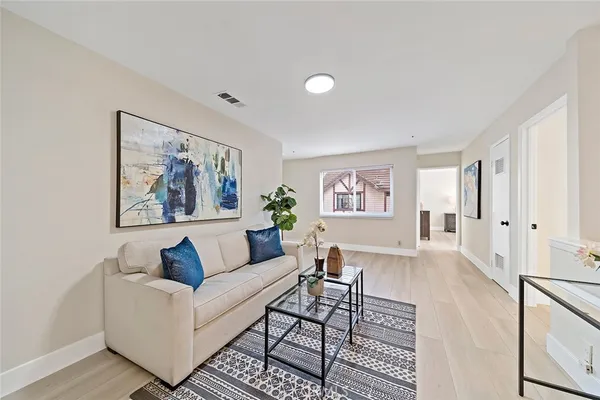 a living room with furniture and a painting on the wall