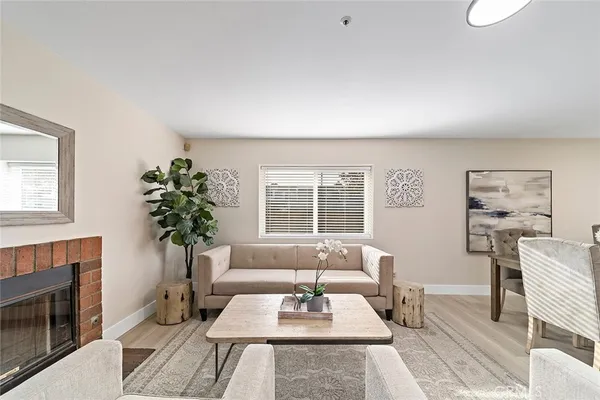 a living room with furniture a potted plant and a fireplace