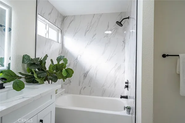 a bathroom with a shower sink vanity and a bathtub