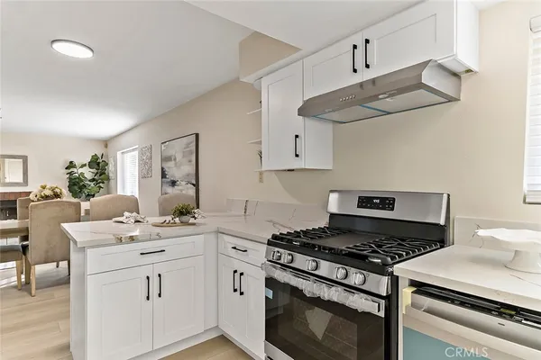 a kitchen with cabinets appliances and wooden floor