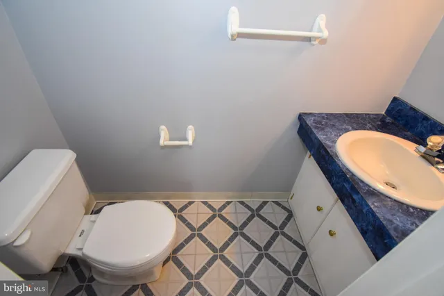 a bathroom with a granite countertop toilet and a sink