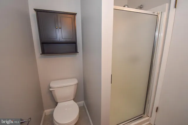 a white toilet sitting next to a shower