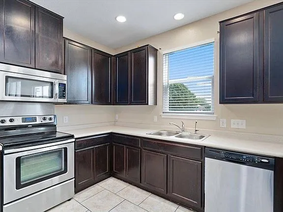 a kitchen with stainless steel appliances granite countertop a sink stove and microwave
