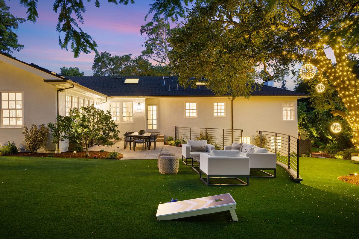 a view of a patio with couches table and chairs and garden
