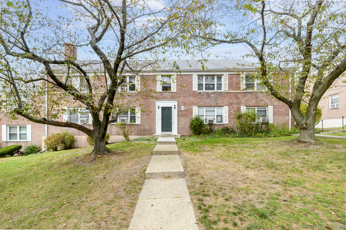1046 East Main Street, Unit 4 Stamford, CT 06902 - Photo 1 of 11 a front view of a house with a yard and trees