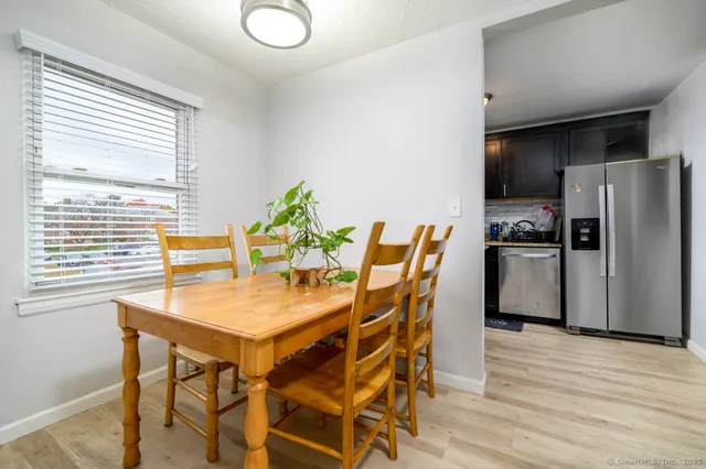 a view of a dining room with furniture and a refrigerator