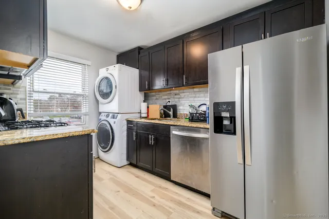 a kitchen with kitchen island wooden cabinets a refrigerator a sink and a stove