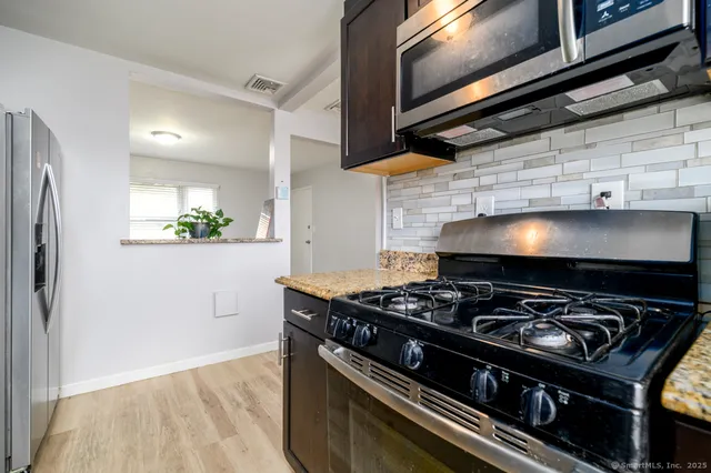 a stove top oven sitting inside of a kitchen