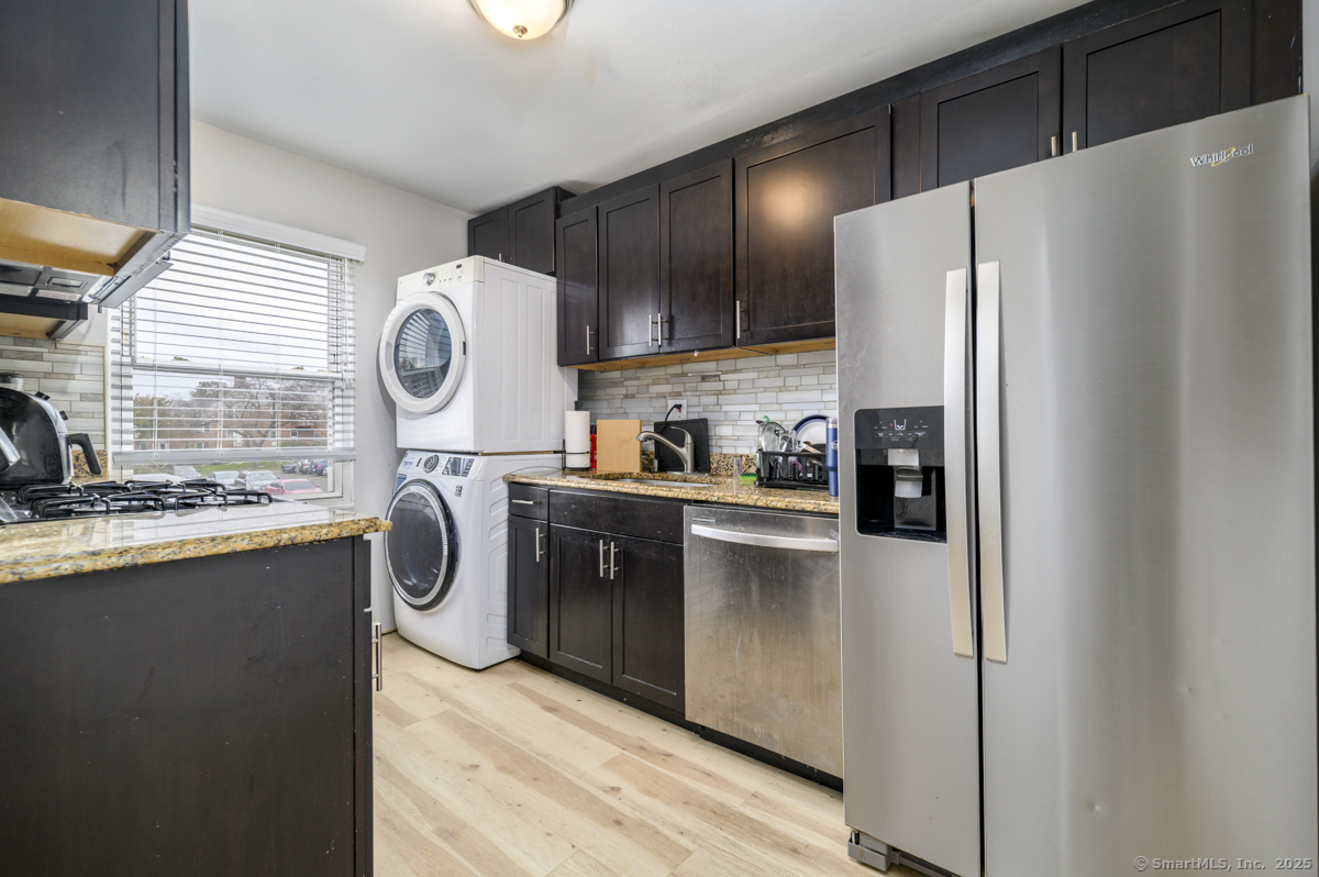 1046 East Main Street, Unit 4 Stamford, CT 06902 - Photo 4 of 11 a kitchen with kitchen island wooden cabinets a refrigerator a sink and a stove