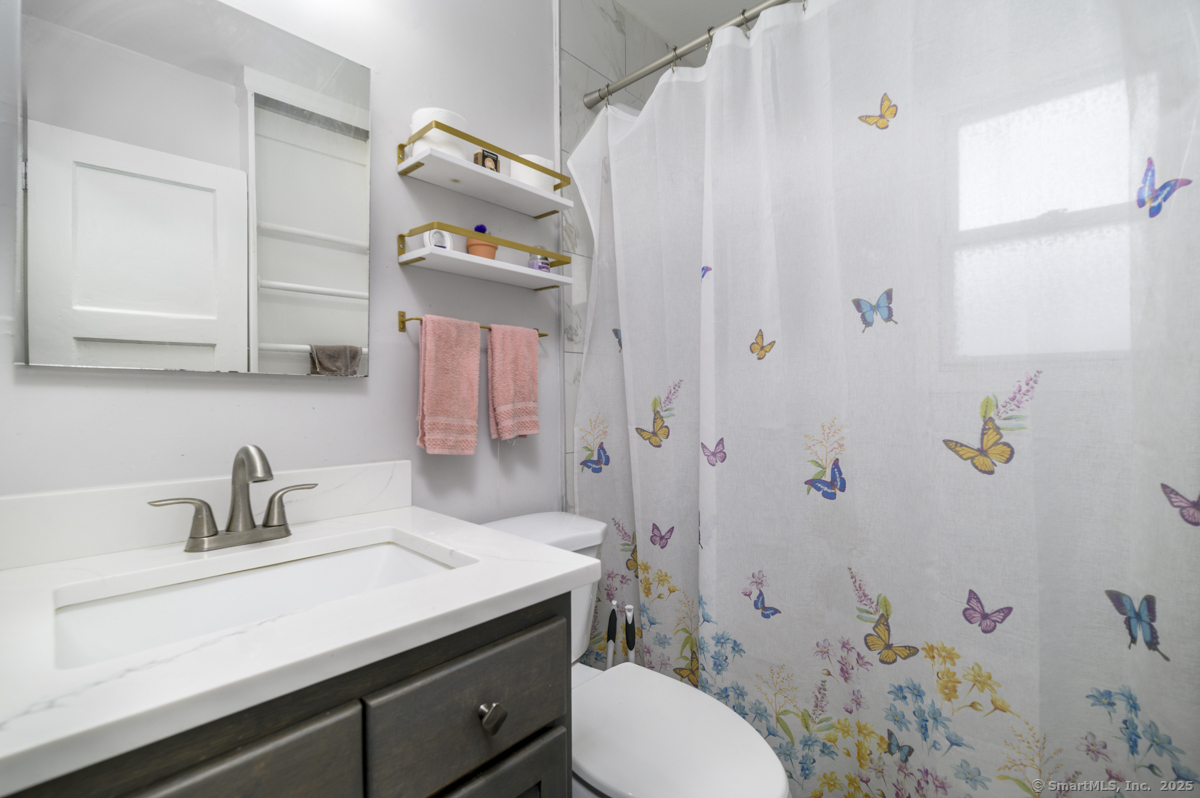 1046 East Main Street, Unit 4 Stamford, CT 06902 - Photo 8 of 11 a bathroom with a sink a toilet and shower curtain