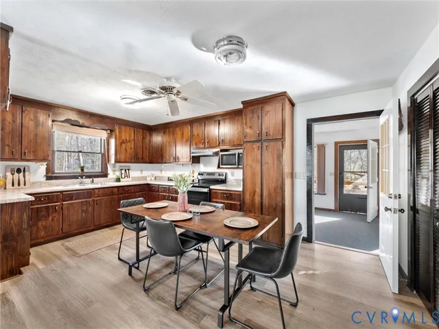 a view of a big room with windows and chandelier fan