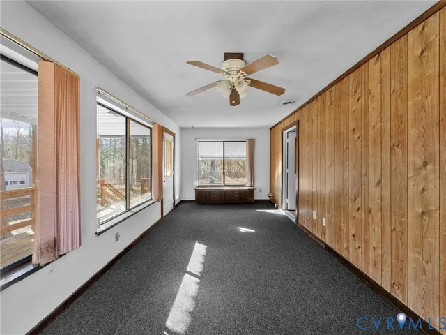 a view of a big room with windows and chandelier fan
