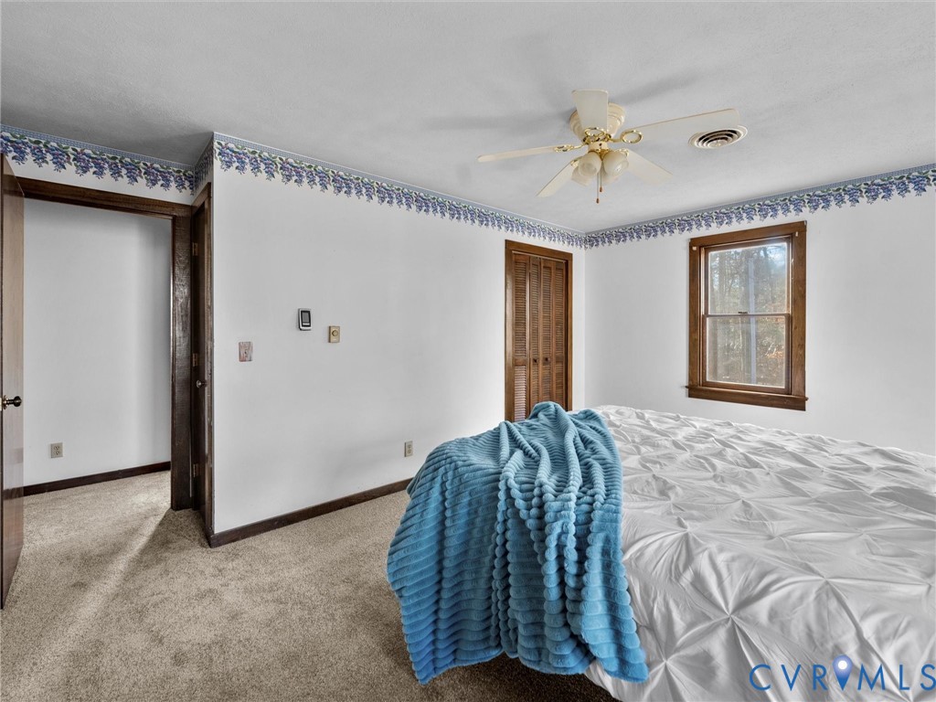 4905 Old Buckingham Road Powhatan, VA 23139 - Photo 20 of 50 a bedroom with a bed and a chandelier