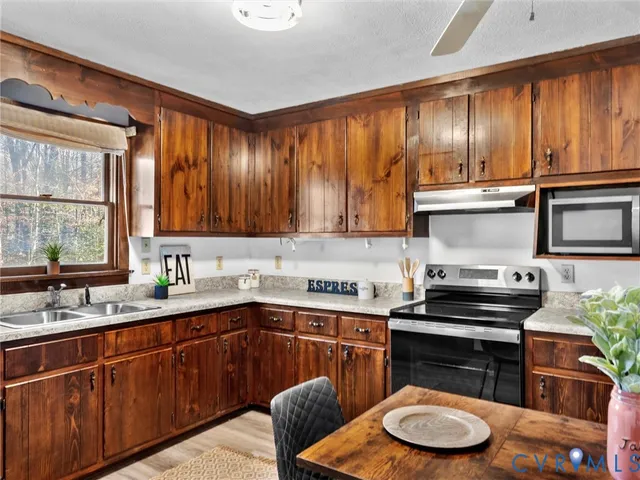 a kitchen with granite countertop cabinets stainless steel appliances dining table and chairs