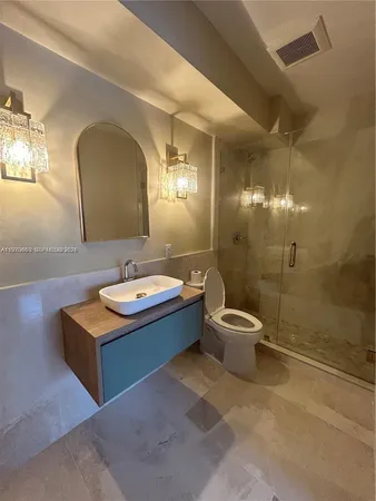 a bathroom with a double vanity sink toilet mirror and shower