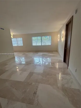 a view of a hallway of a livingroom with window